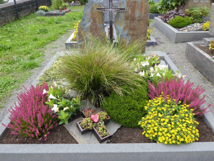 grave planted with evergreens and colourful bedding
